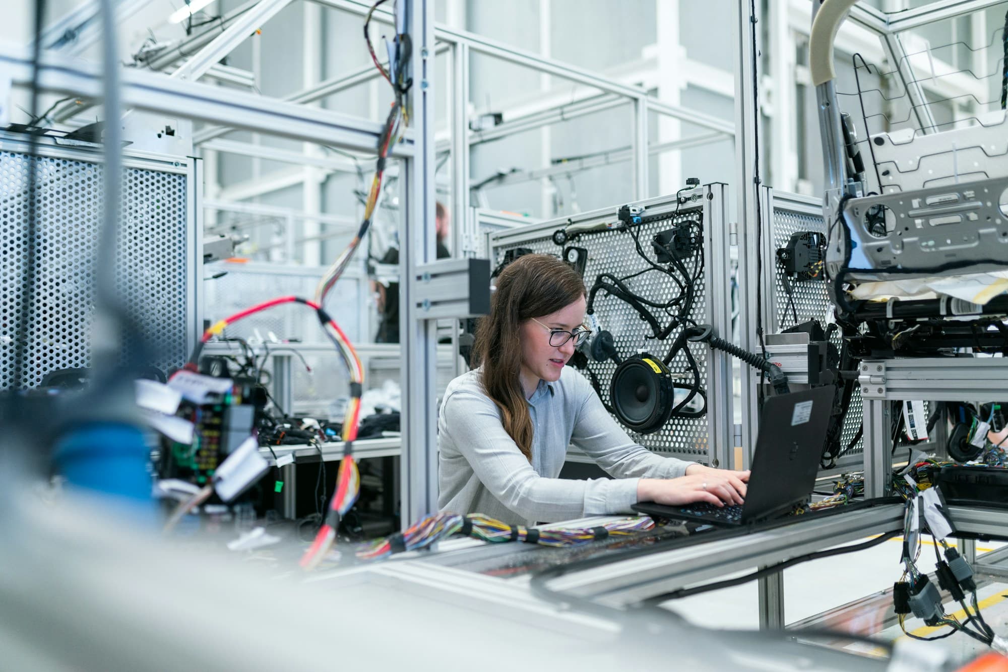 An engineer working on a laptop in a manufacturing lab